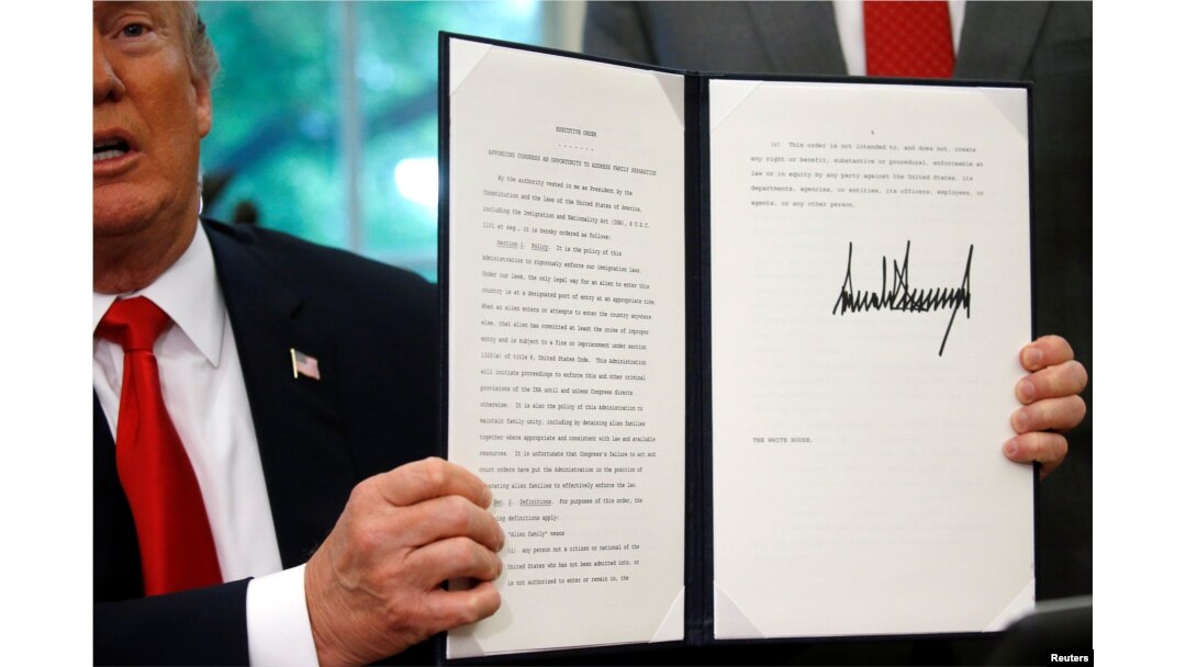 U.S. President Donald Trump displays an executive order on immigration policy after signing it in the Oval Office at the White House in Washington, June 20, 2018.
