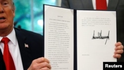 Le président des États-Unis, Donald Trump, présentant son décret sur la politique migratoire dans le bureau ovale de la Maison Blanche à Washington, le 20 juin 2018.