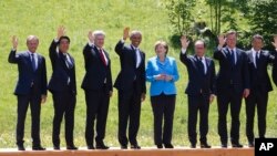 Kanselir Angela Merkel (tengah) berpose bersama para pemimpin negara anggota G7 di Schloss Elmau dekat Garmisch-Partenkirchen, Jerman selatan, Minggu (7/6).
