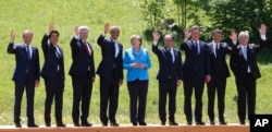 German Chancellor Angela Merkel (C) poses with G7 leaders during a group photo at the G7 summit at Schloss Elmau near Garmisch-Partenkirchen, southern Germany, June 7, 2015.