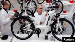Pierre Forte (R), founder and CEO of Pragma Industries, and Alexandre Blanc (L), operations director, check an Alpha bike, first industrialized bicycle to use a hydrogen fuel cell at the Pragma Industries factory in Biarritz, France, Jan. 15, 2018. 