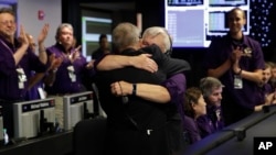 Project manager Earl Maize, center left, and flight director Julie Webster hug in mission control at NASA's Jet Propulsion Laboratory, Sept. 15, 2017, in Pasadena, Calif., after confirmation of Cassini's demise.