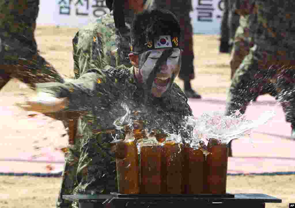 A soldier from the South Korean army special forces uses his hand to break beer bottles as part of the reenactment event of the Battle of the Naktong Bulge near the Waegwan railway bridge in Waegwan, South Korea. 