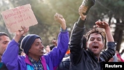 FILE - Migrants from Bangladesh shout 'Open the border!' as they protest while waiting to cross the border from Greece into Macedonia, near Gevgelija, Macedonia, Nov. 26, 2015. 