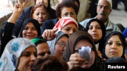 Para perempuan antre di sebuah tempat pemungutan suara pada referendum di Mesir (14/1).