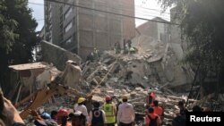 Masyarakat membersihkan puing-puing bangunan setelah gempa mengguncang Mexico City, Meksiko, 19 September 2017. 