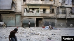 Warga sipil di luar gedung di kota Aleppo yang diledakkan pasukan pemerintah Suriah pada 25/8. (Foto: Reuters)