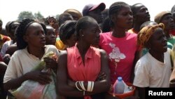 Displaced refugee women, escaping the violence, wait to receive humanitarian aid at the airport outside the capital Bangui, Central African Republic.