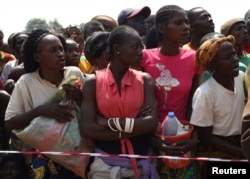 FILE - Displaced refugee women, escaping the violence, wait to receive humanitarian aid at the airport outside the capital Bangui, Central African Republic, Jan. 7, 2014.