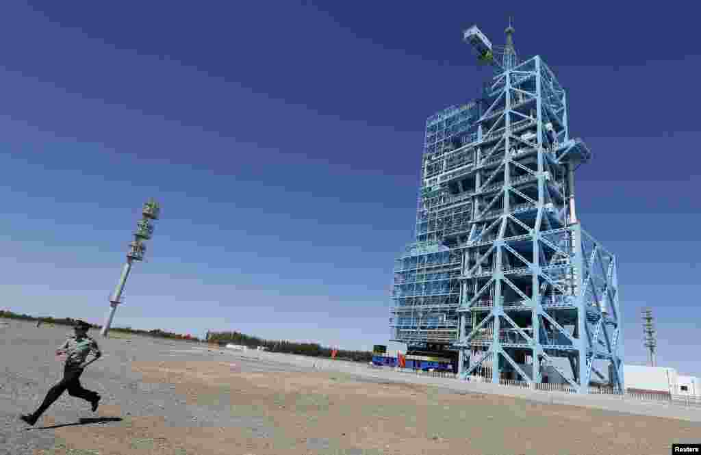 A soldier runs away from the launch pad holding the Shenzhou-10 manned spacecraft at Jiuquan satellite launch center in Jiuquan, Gansu province, China, June 10, 2013.