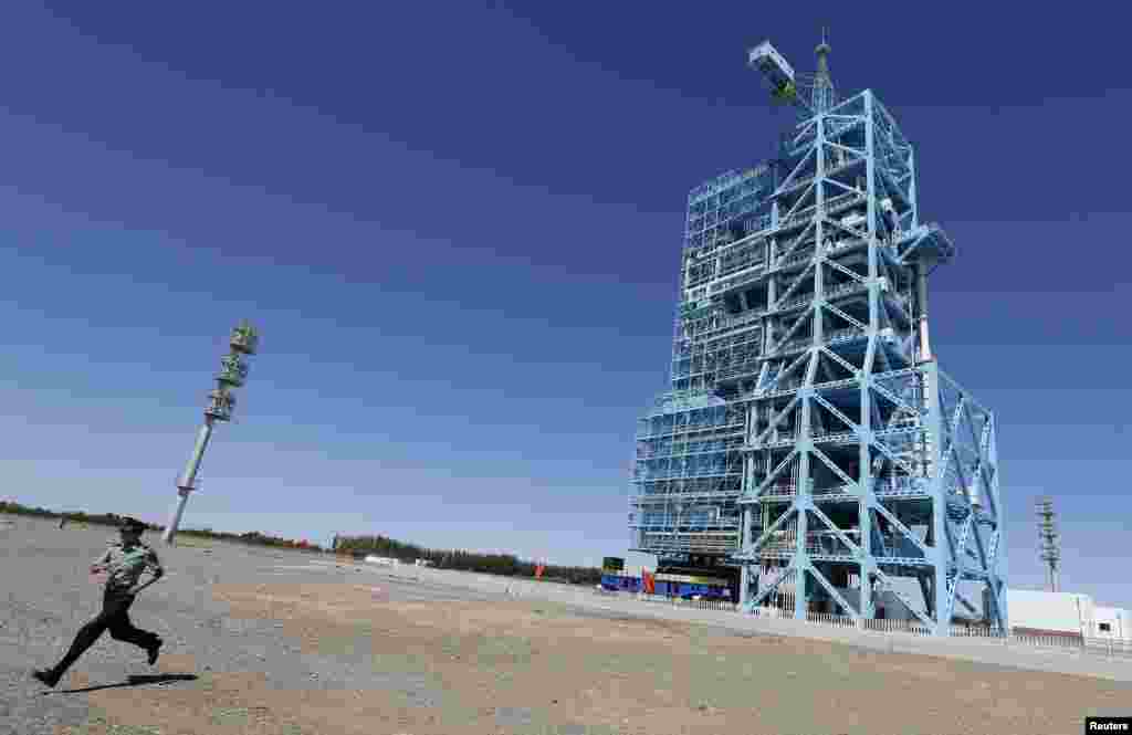 A soldier runs away from the launch pad holding the Shenzhou-10 manned spacecraft at Jiuquan satellite launch center in Jiuquan, Gansu province, China, June 10, 2013. 