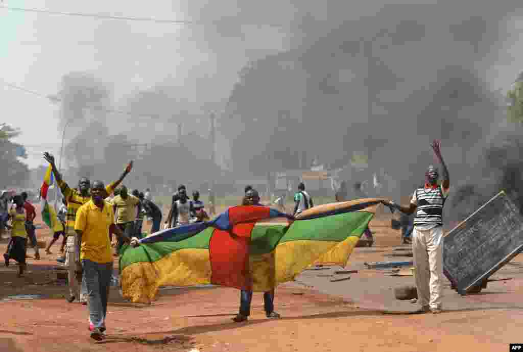 People hold a Central African flag as they protest against the French &quot;Sangaris&quot; intervention in the Galabadia neighborhood close to President Michel Djotodia&#39;s private house in the eigth district of Bangui.
