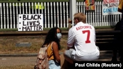 Seorang pria mengenakan seragam mantan gelandang NFL Colin Kaepernick menjelang protes Black Lives Matter di Forbury Gardens di Reading, Inggris, 13 Juni 2020. (Foto: REUTERS/Paul Childs)