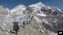 FILE - Climbers pass through a glacier at the Mount Everest base camp, Nepal, Feb. 22, 2016.