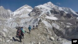 FILE - Climbers pass through a glacier at the Mount Everest base camp, Nepal, Feb. 22, 2016.