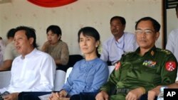 ရန်ကုန် သုဝဏ္ဏအားကစားကွင်းတွင် မြန်မာ - လာအို ဘောလုံးပွဲကို ကြည့်ရှုနေကြသည့် ဒေါ်အောင်ဆန်းစုကြည်၊ မြန်မာဘောလုံးအဖွဲ့ချုပ် ဥက္ကဋ္ဌ ဦးဇော်ဇော်နှင့် ရန်ကုန်တိုင်း ဒေသကြီး လုံခြုံရေးဝန်ကြီးတို့ကို တွေ့ရစဉ်။ Sept. 14, 2011. (AP)
