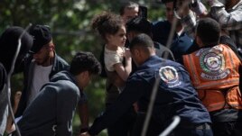 Suzy and her father Riad were the only survivors of their family after an Israeli airstrike destroyed one of the buildings they lived in in Gaza City early Sunday, killing her mother and four siblings. (AP Photo/Khalil Hamra, File)