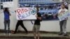 Protesters stand on the street with placards reading "Beep your horn for the Whales" outside the building where the International Whaling Commission (IWC) is being held during this week in Panama City, July 4, 2012. 