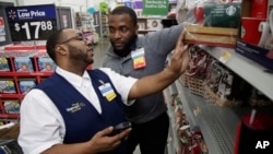 FILE - A Walmart employee, left, is coached by a trainer to use an inventory app at a Walmart store in North Bergen, New Jersey, Nov. 9, 2017. Nonfarm payrolls in the U.S. increased by 134,000 in September, according to a Labor Department report.