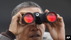 奥巴马总统3月25日在南北韩非军事区用望远镜向北韩方向眺望