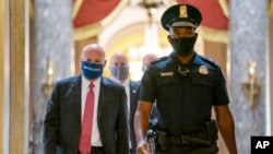 Louis DeJoy (hagu) tare da wani dan sanda (dama) bayan ya gama tattaunawa da kakakin majalisar wakilai, Nancy Pelosi
