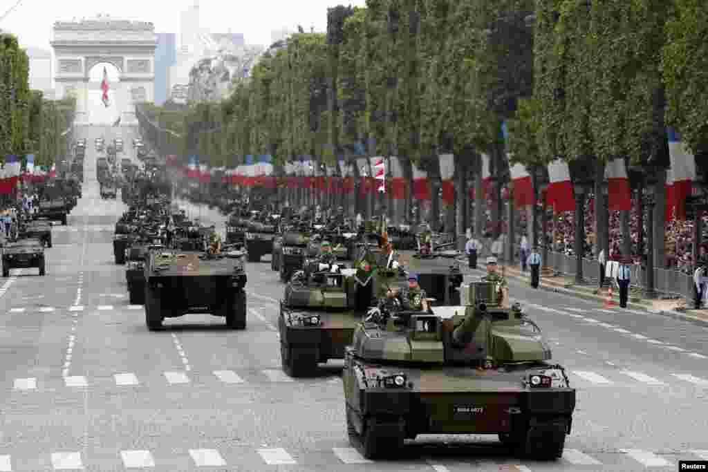 Tanks rumble down the Champs-Elysee during the traditional Bastille Day parade in Paris, July 14, 2014.