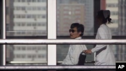 Chinese activist activist Chen Guangcheng (L) is seen in a wheelchair pushed by a nurse at Chaoyang hospital in Beijing, May 2, 2012. 