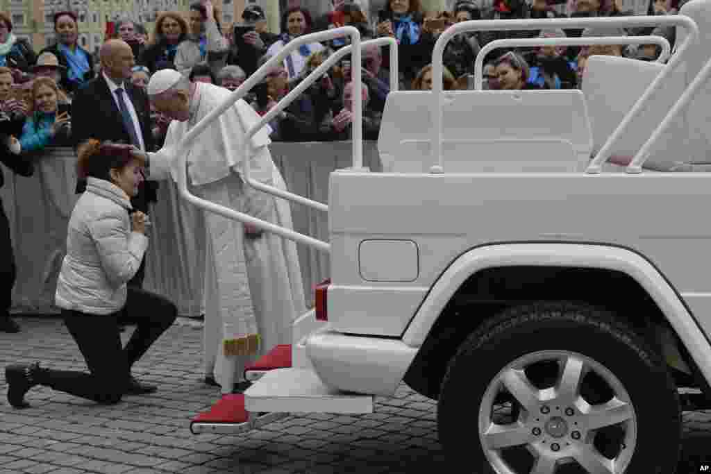 زنی مقابل پاپ فرانسیس در مقابل میدان پیتر در واتیکان زانو زد و پاپ او را مورد تفقد قرار داد.&nbsp;