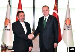President of Turkey Recep Tayyip Erdogan, right, shakes hands with Mahmoud Vaezi, special envoy of Iranian President Hassan Rouhani, at his ruling party headquarters in Ankara, Turkey, May 16, 2018.