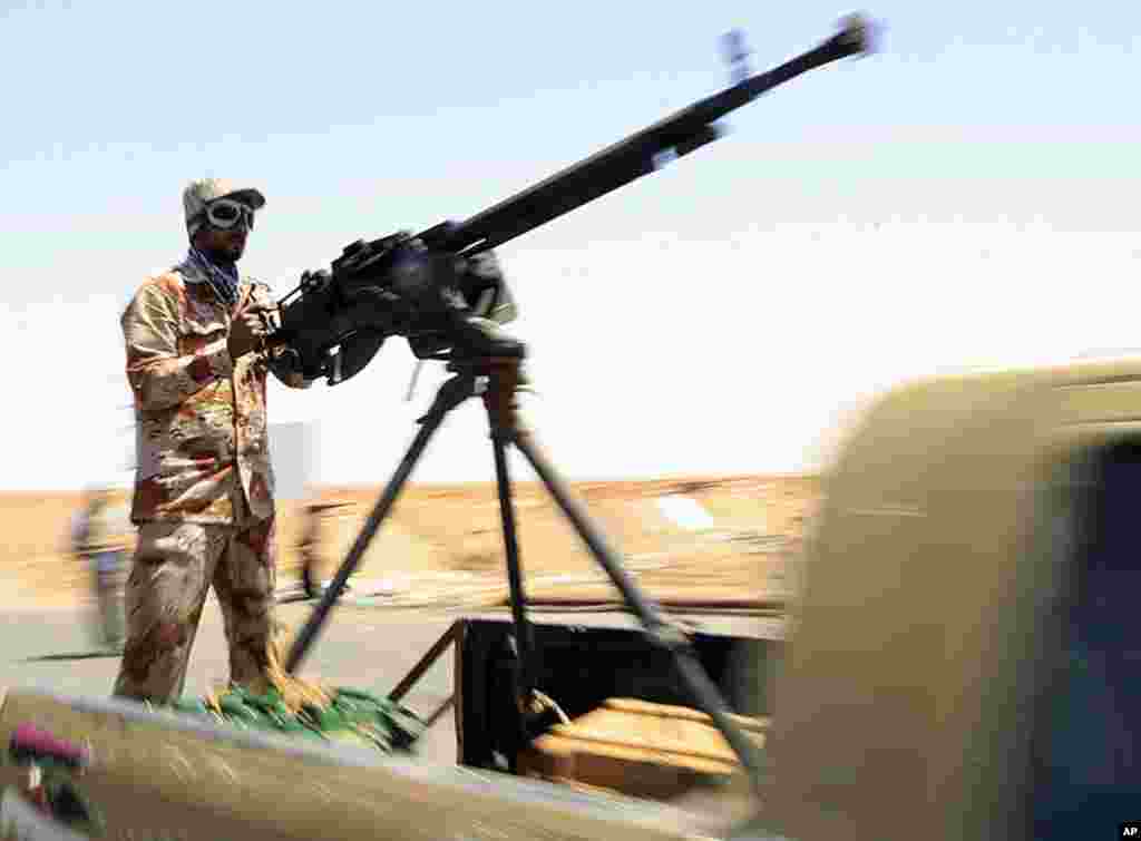 A rebel fighter mans a heavy machine-gun as he takes his position on the frontline along the western entrance of Ajdabiya, April 23, 2011. (Reuters image)