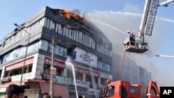 Firefighters work to douse flames on a building in Surat, in the western Indian state of Gujarat, May 24, 2019. At least 19 teenage students were killed in a fire in a four-story building, police said.