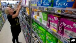 FILE - Tammy Compton restocks tampons at Compton's Market, in Sacramento, Calif., June 22, 2016. Bills to exempt feminine hygiene products and diapers from sales taxes were vetoed by Gov. Jerry Brown in 2016, but the measure's author's are reintroducing the proposals.