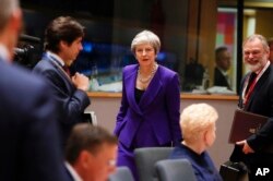FILE - British Prime Minister Theresa May, center, arrives for a round table meeting at an EU summit in Brussels, Oct. 18, 2018.