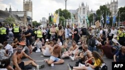 Anti-vaccination protesters sit in central London
