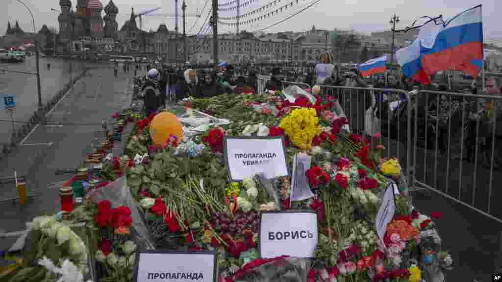 Flowers and pesters reading "Propaganda kills! Fight!" are seen at the place where Boris Nemtsov was gunned down on Friday near the Kremlin, with St. Basil Cathedral is in the background, in Moscow, Russia, March 1, 2015. 