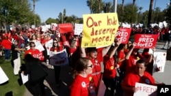 Arizona teachers and education advocates march at the Arizona Capitol highlighting low teacher pay and school funding Wednesday, March 28, 2018, in Phoenix. (AP Photo/Ross D. Franklin)