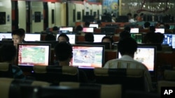 FILE - Customers surf the Internet at an Internet cafe in Beijing, China.