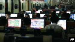 FILE - Customers surf the Internet at an Internet cafe in Beijing, China.