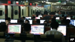 FILE - Customers surf the Internet at an Internet cafe in Beijing, China.