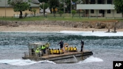FILE - A group of Vietnamese asylum seekers are taken by barge to a jetty on Australia's Christmas Island, April 14, 2013.