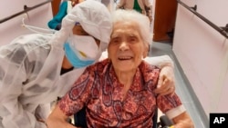 In this photo taken on April 1, 2020, 103-year-old Ada Zanusso, poses with a nurse at the old people's home "Maria Grazia" in Lessona, northern Italy, after recovering from Covid-19 infection. (Residenza Maria Grazia Lessona via AP Photo)