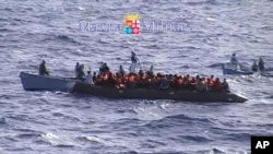 FILE: Migrants receive help from two raft from the Italian Navy ship Libra, off the Sicilian island of Lampedusa Saturday, Oct.12, 2013. 