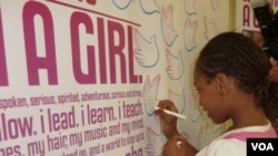 Seorang remaja perempuan di Chicago sedang menandatangani dukungan terhadap kampanye "Girl Up".