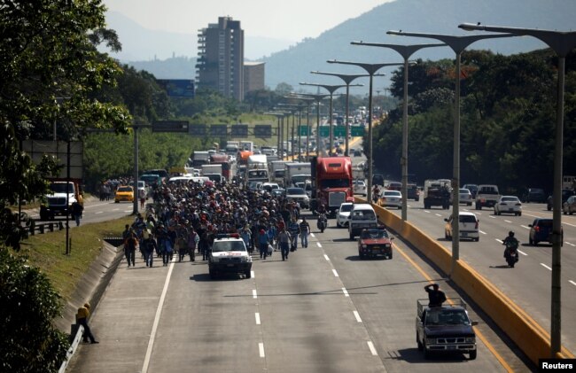 People walk in a caravan of migrants departing from El Salvador en route to the United States, in San Salvador, El Salvador, Oct. 31, 2018.