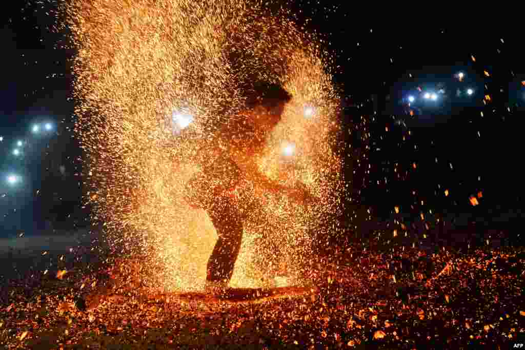 Seorang pria dari suku Pa Then melakukan &quot;tarian api&quot; pada festival menyambut musim semi di Lam Binh, provinsi Tuyen Quang, Vietnam utara.