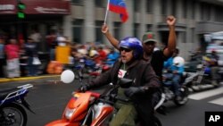 Motorcyclists waving a Venezuelan flag attend a rally in support of Venezuela's President Nicolas Maduro in Caracas, Feb. 24, 2014.