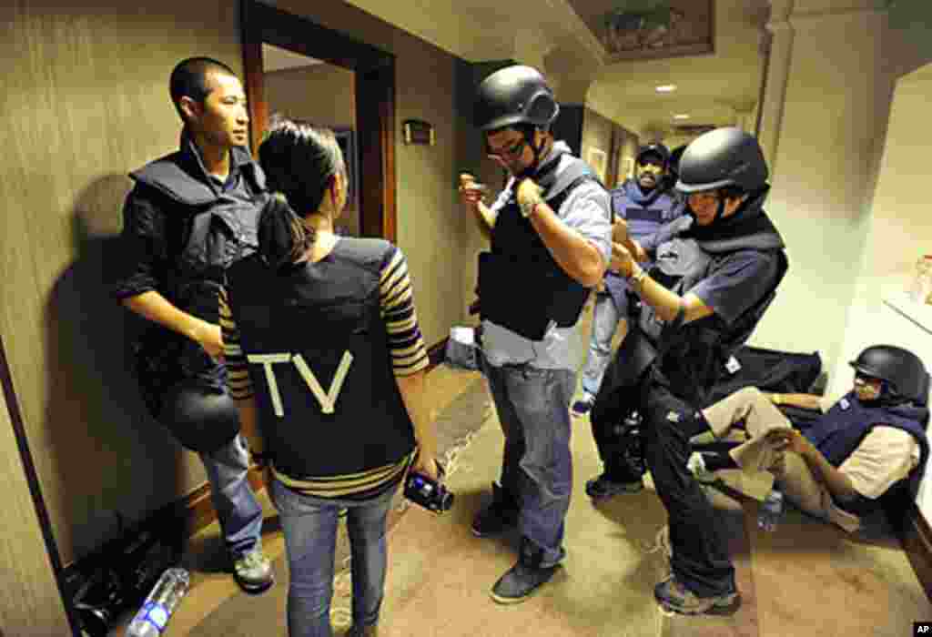 Members of the media mark their flak jackets with TV initials at the Rixos hotel in Tripoli, Aug. 21, 2011. Heavy gunfire rang out near the Tripoli hotel where members of the foreign media are staying. (Reuters)