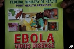 Nigeria health official display a leaflet explaining Ebola Virus Disease at the arrival hall of Murtala Muhammed International Airport in Lagos, Nigeria, Aug. 4, 2014.