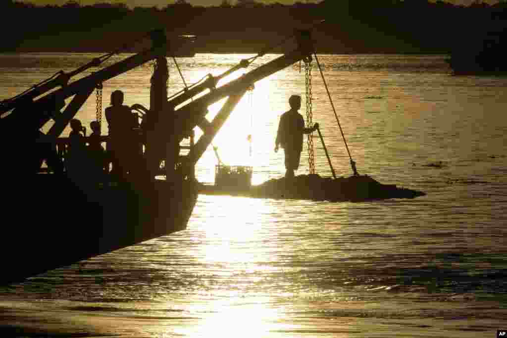 A passenger stands on the foredeck of a ferry as it crosses the Mekong river from Arey Ksat to the main city of in Phnom Penh, Cambodia. Ferries are used daily to transport villagers and products over the Mekong and Tonle Sap rivers from Arey Ksat to Phnom Penh.