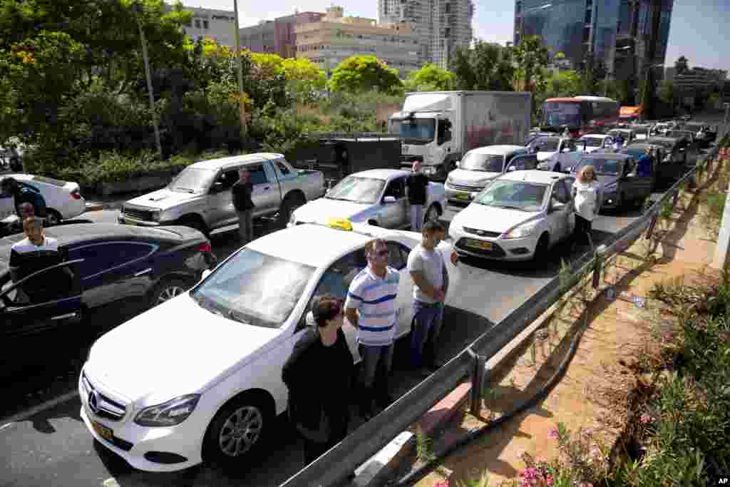 Israelis stand still next to their cars as a siren sounds in memory of victims of the Holocaust in Tel Aviv, Israel.